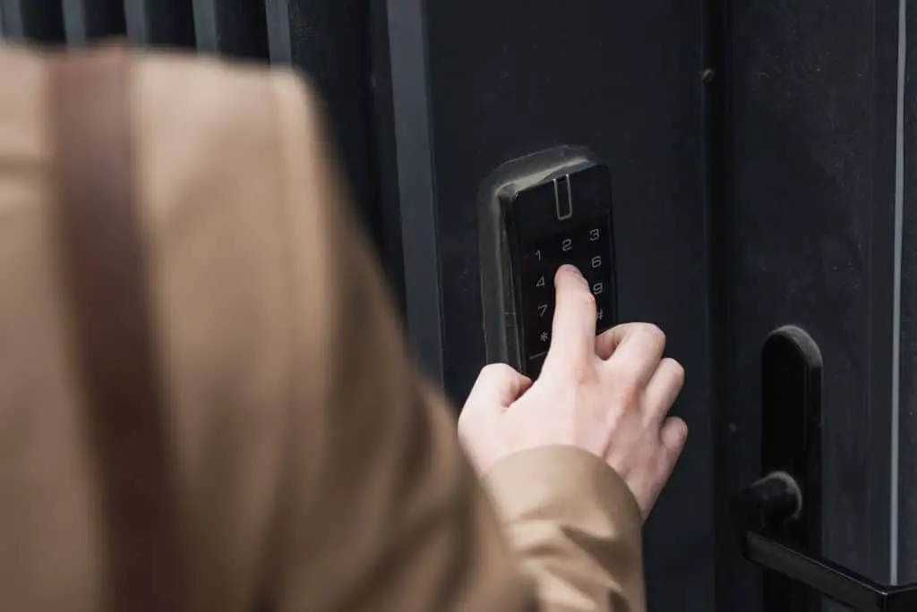 Someone entering keys on a door lock intercom